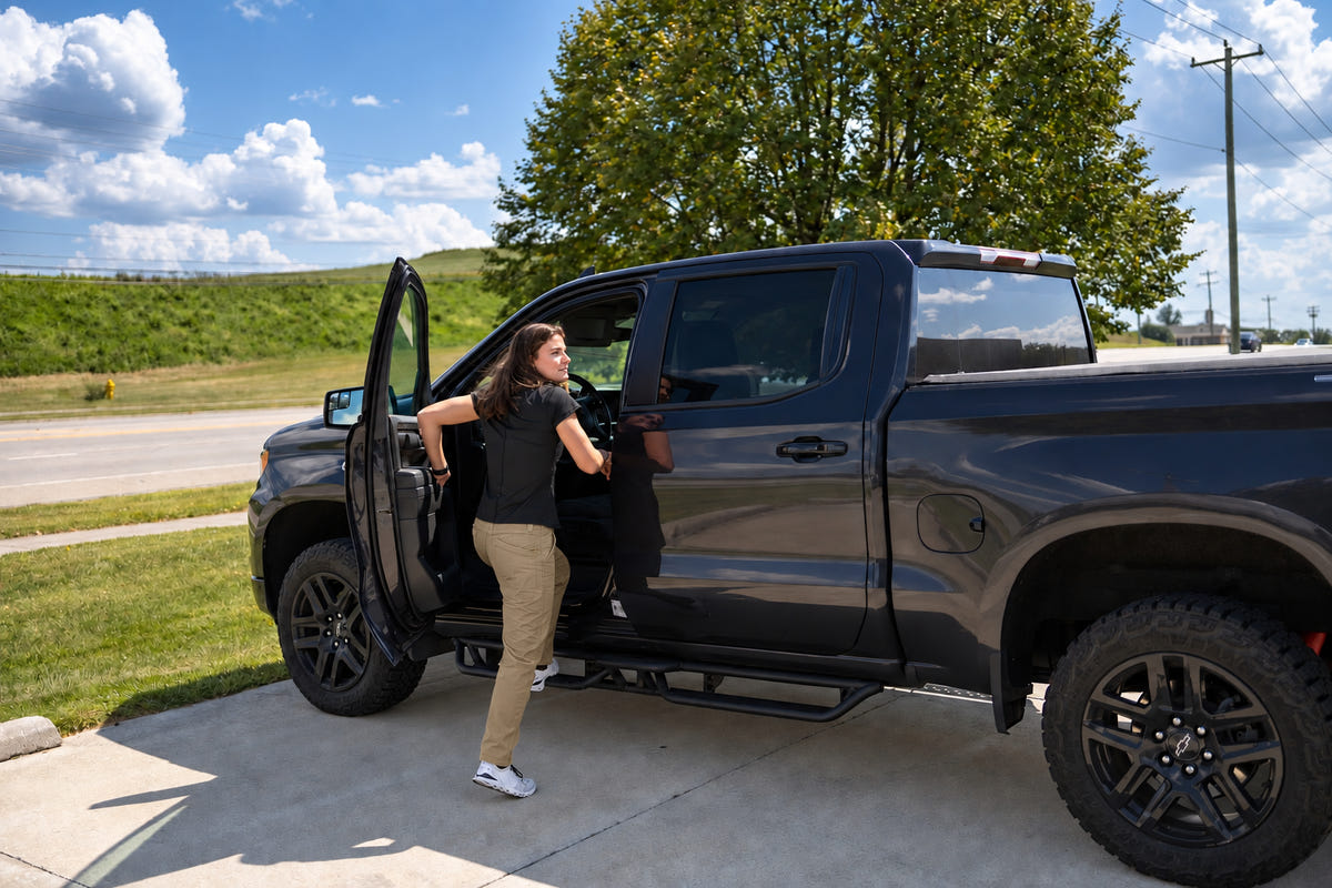 Woman wearing tan MGT Gear workwear pants beside a truck