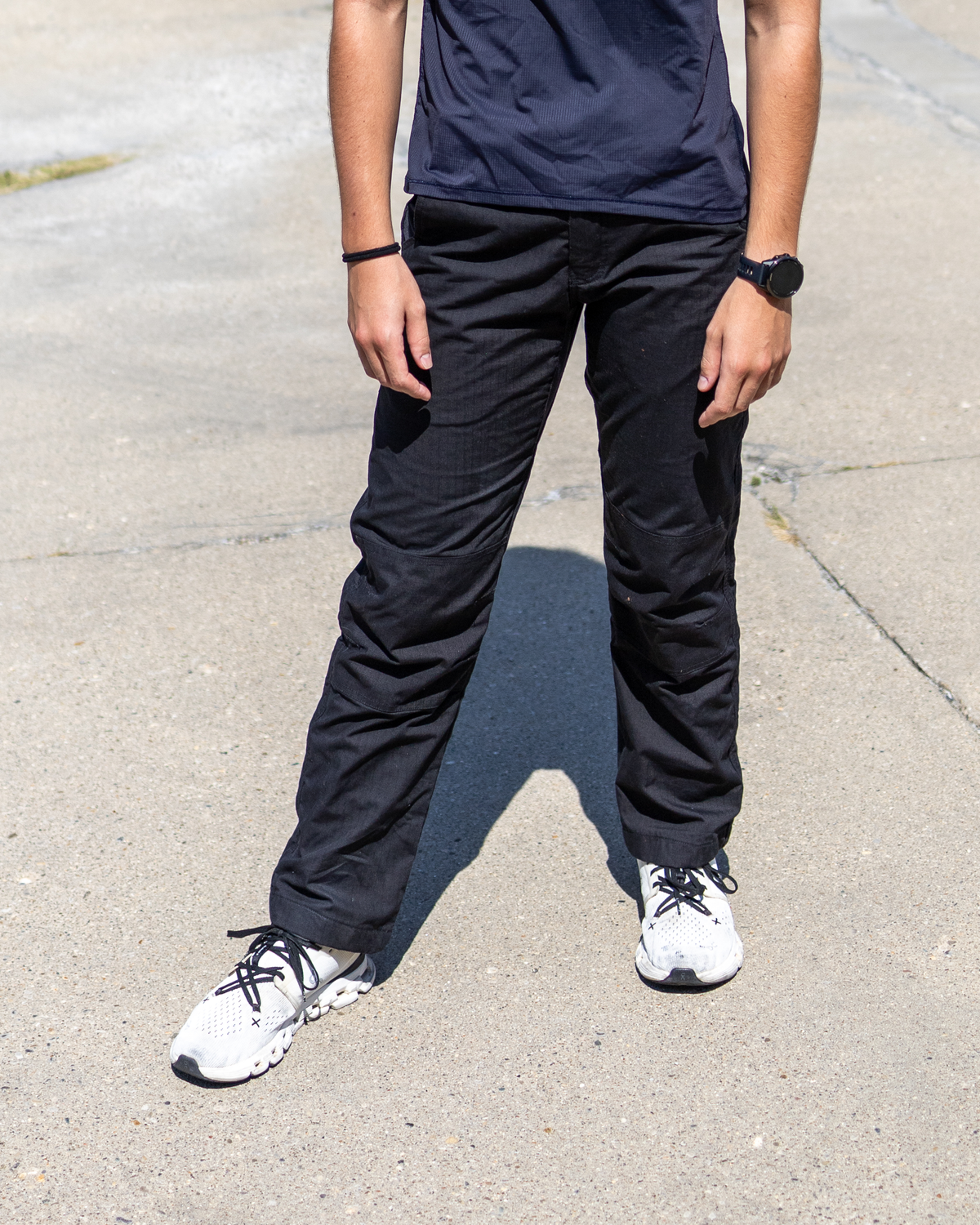 Woman wearing black MGT Gear workwear pants, front view from waist to shoes